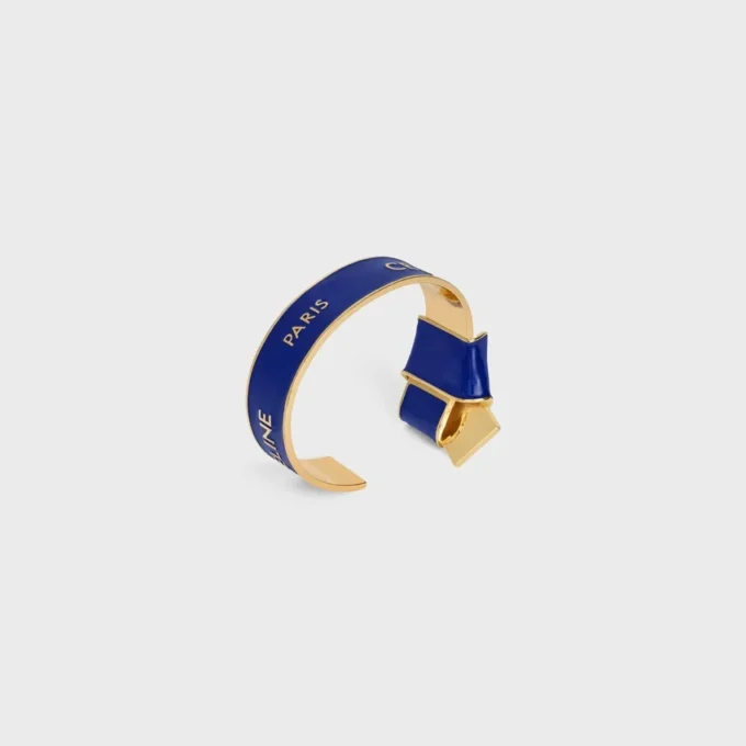 CELINE Ribbon Knotted Cuff i emalj och mässing med guldfinish CELINE Ribbon Knotted Cuff i emalj och mässing med guldfinish