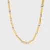 Långt halsband med berlocker i mässing med guld- och rodiumfinish Långt halsband med berlocker i mässing med guld- och rodiumfinish