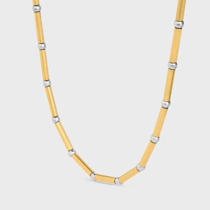 Långt halsband med berlocker i mässing med guld- och rodiumfinish Långt halsband med berlocker i mässing med guld- och rodiumfinish