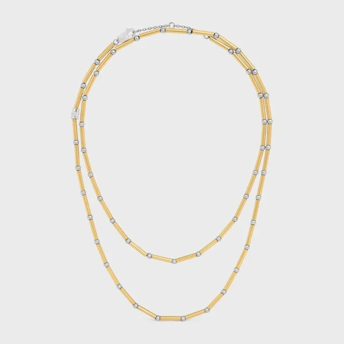 Långt halsband med berlocker i mässing med guld- och rodiumfinish Långt halsband med berlocker i mässing med guld- och rodiumfinish