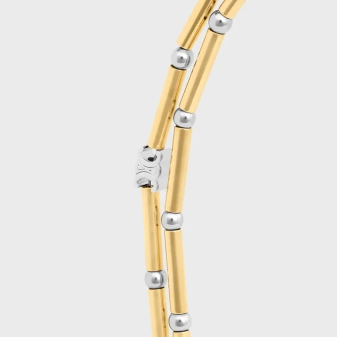Långt halsband med berlocker i mässing med guld- och rodiumfinish Långt halsband med berlocker i mässing med guld- och rodiumfinish