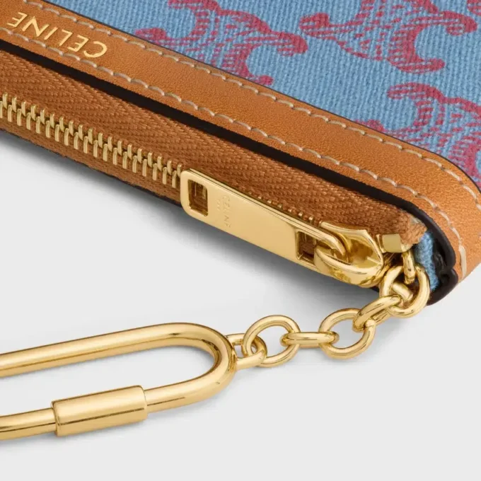 Myntficka  i textil med Triomphe-mönster över hela ytan