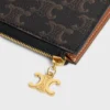 Set med tre påsar Triomphe-berlocker i Triomphe Canvas och kornigt kalvskinn Set med tre påsar Triomphe-berlocker i Triomphe Canvas och kornigt kalvskinn