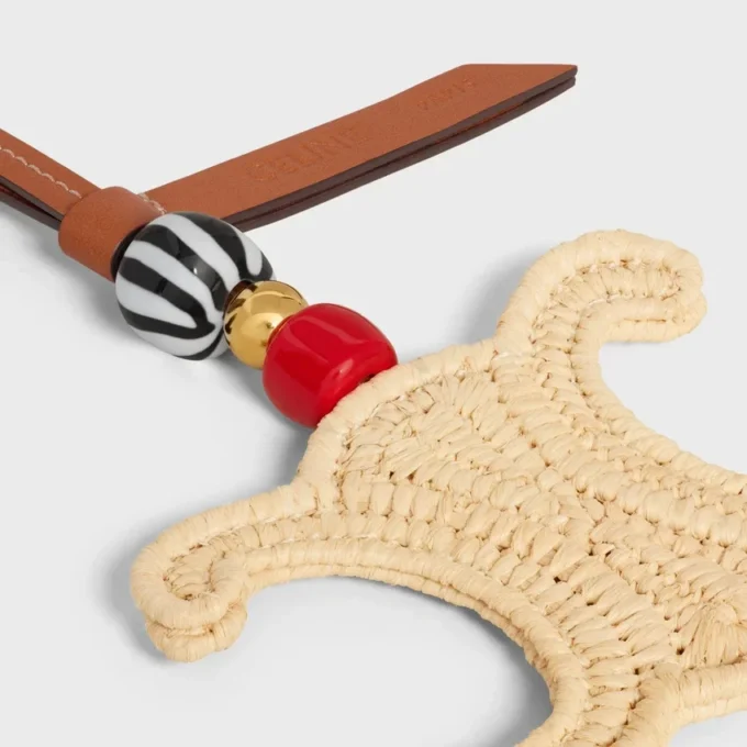 Triomphe-berlock i raffia och naturligt kalvskinn